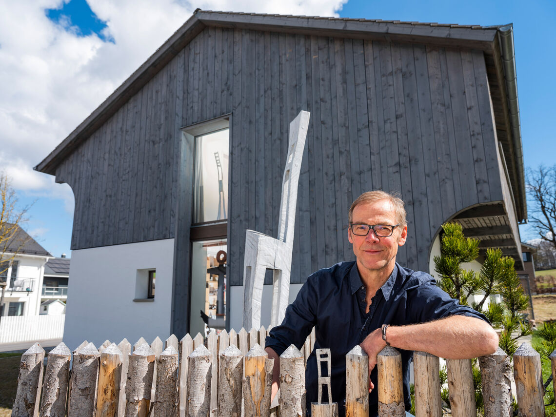 Ungewöhnliche Architektur: Ein Besuch zuhause bei Künstler Hans Panschar Hans Panschar steht am Zaun gelehnt vor seinem Haus