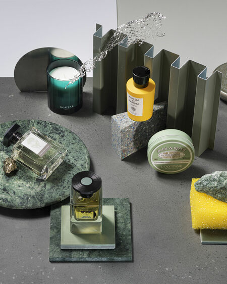 Stilleben mit grünen und gelben Beauty-Produkten auf Mamorplatten und Oberflächen in Grau und Blau