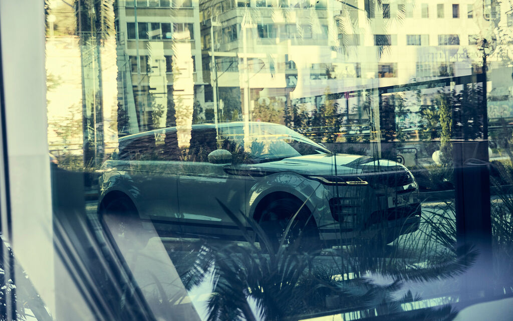 Stadttauglicher SUV: Der Range Rover Evoque 2019 im Test Range Rover Evoque spiegelt sich in einer Fensterscheibe in einem Wohnviertel in Athen