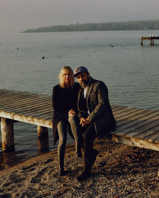 Franziska and Adnan Maral sitting on a wooden jetty at Ammersee