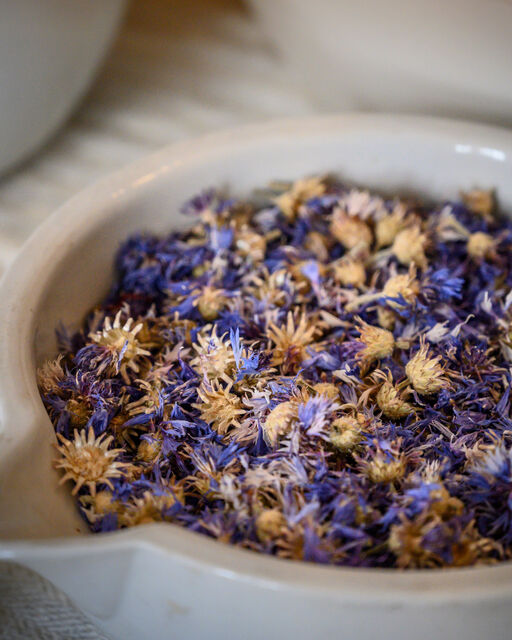Bayerische Klöster im Wandel der Zeit: Naturkosmetik aus Kloster Wessobrunn Nahaufnahme getrockneter blauer Blüten in weißer Apothekerschale