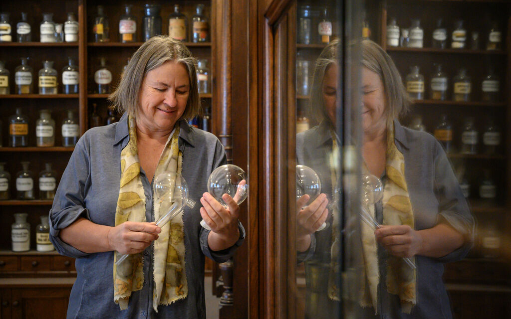 Bayerische Klöster im Wandel der Zeit: Naturkosmetik aus Kloster Wessobrunn Martina Gebhardt steht in Apotheke des Klosters Wessobrunn und blickt auf Gefäß mit Naturkosmetik