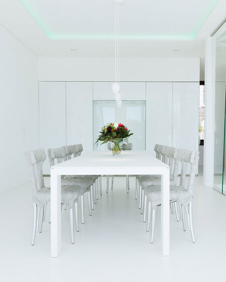 Interior-Aufnahme eines minimalistisch eingerichteten Esszimmers mit weißen Wänden und Möbeln