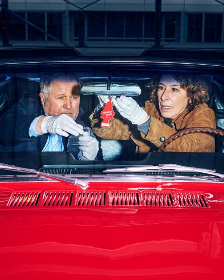 Harald Krassnitzer und Adele Neuhauser auf den Vordersitzen eines roten Mustang