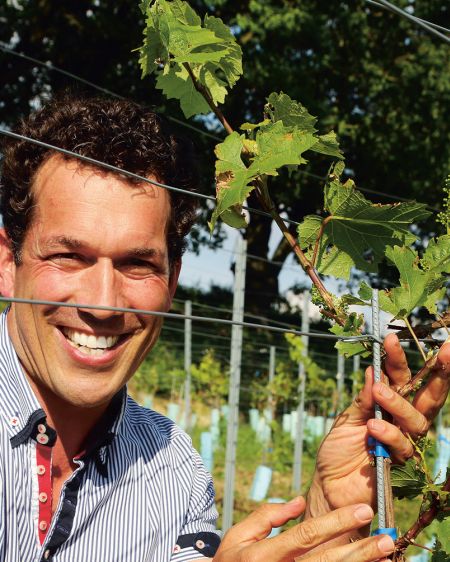 Porträtfoto von Winzer Uli Ernst vor Hang mit Weinreben