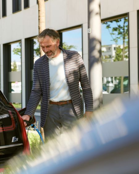 Mann lädt sein E-Auto an einer Ladestation der Stadtwerke München auf
