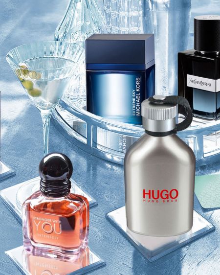 Gin-Tonic-Glas steht zwischen verschiedenen Flakons mit Herrendüften