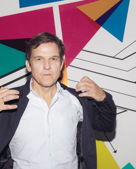 Christoph Schneider, Amazon-Prime Chef vor Wand mit bunten Pfeilen